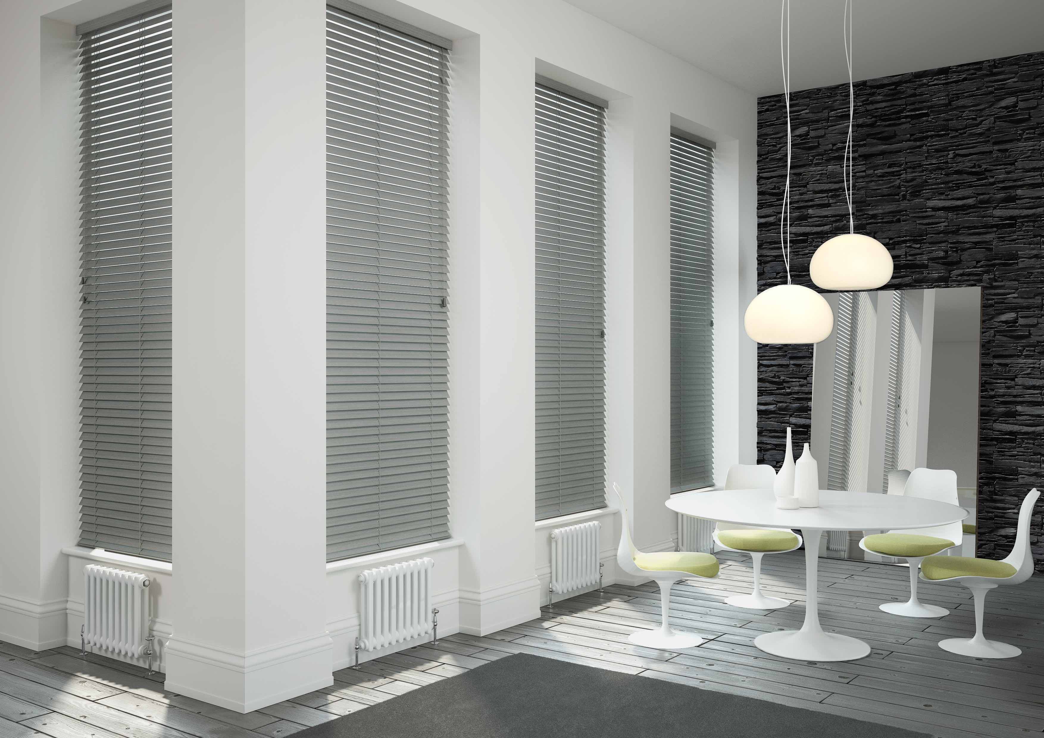 White venetian blinds closed behind a sink in a white and gray marble kitchen