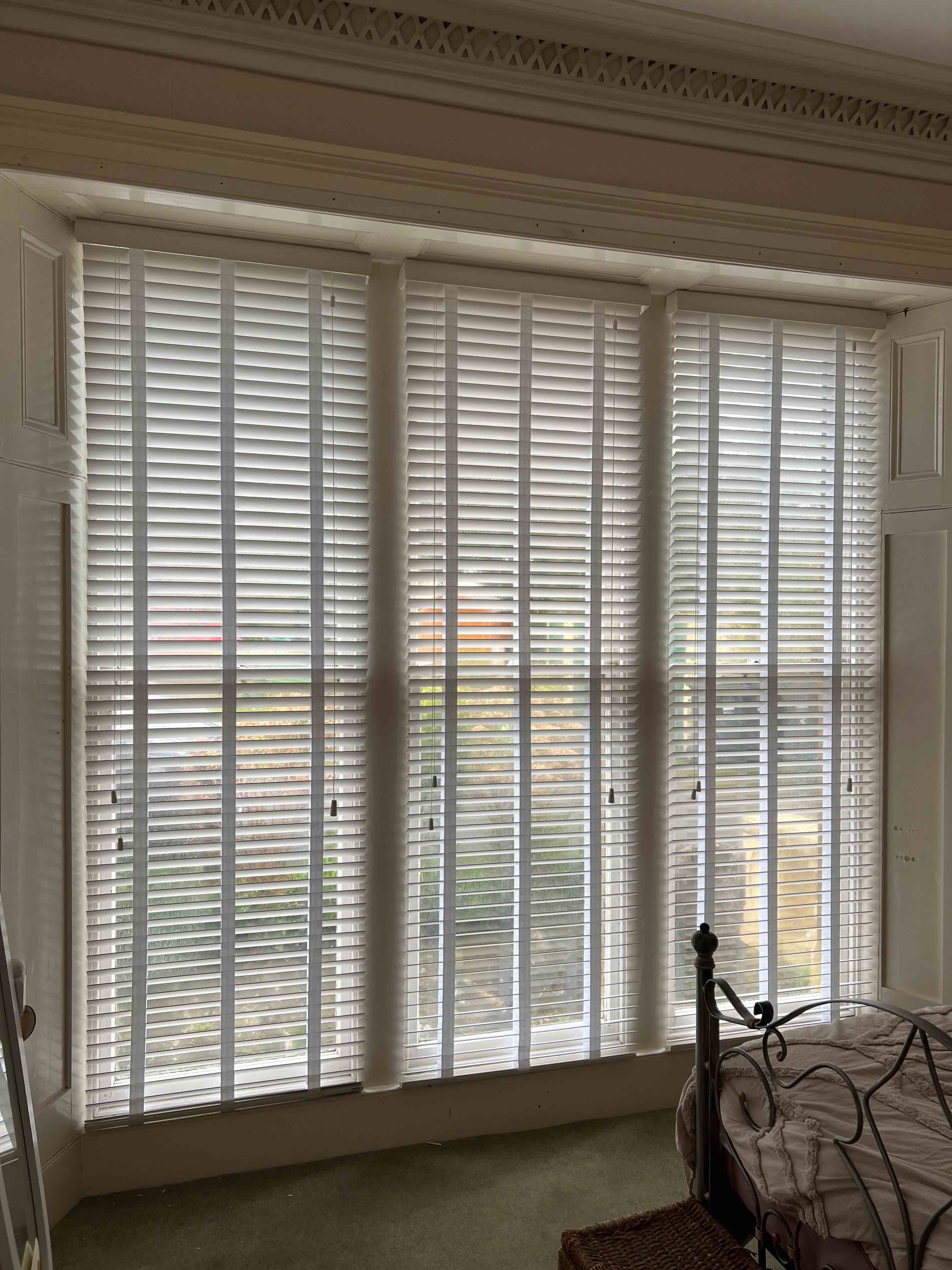 Some wooden venetian blinds in a bay window